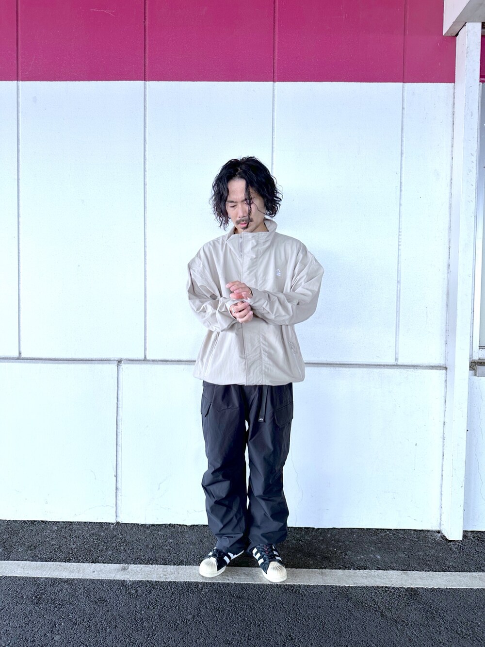 グレー系のナイロンジャケット、ブラック系のカーゴパンツを着用したメンズの秋コーディネートの2枚目の写真