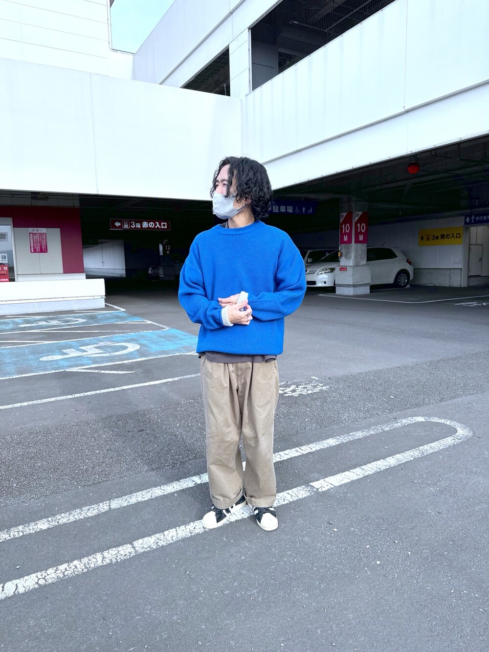 ブルー系のニット/セーターを着用したメンズの秋コーディネートの2枚目の写真