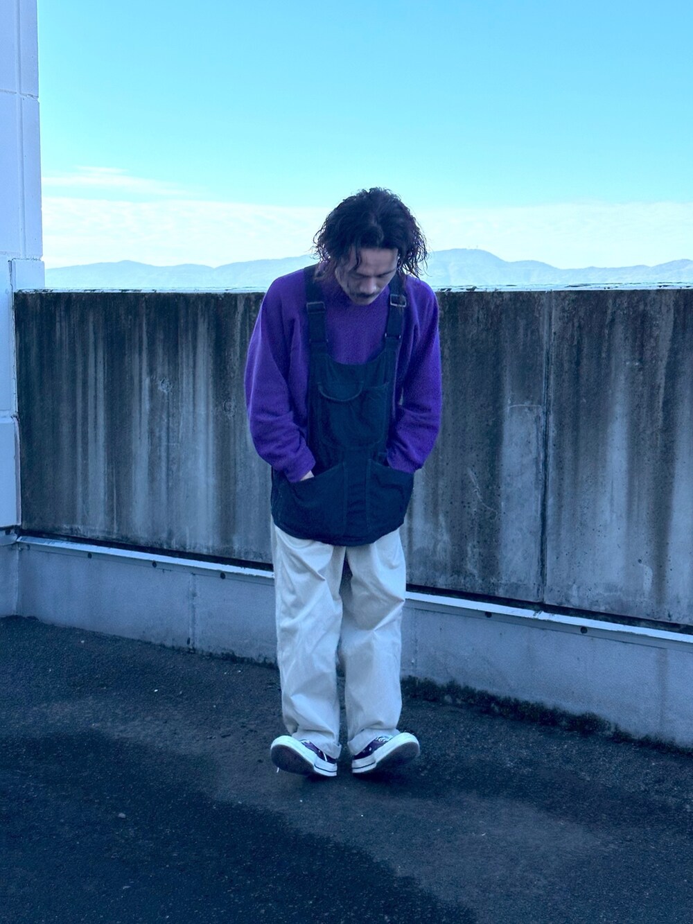 ブラック系のベスト、ベージュ系のチノパンツを着用したメンズの冬コーディネートの2枚目の写真