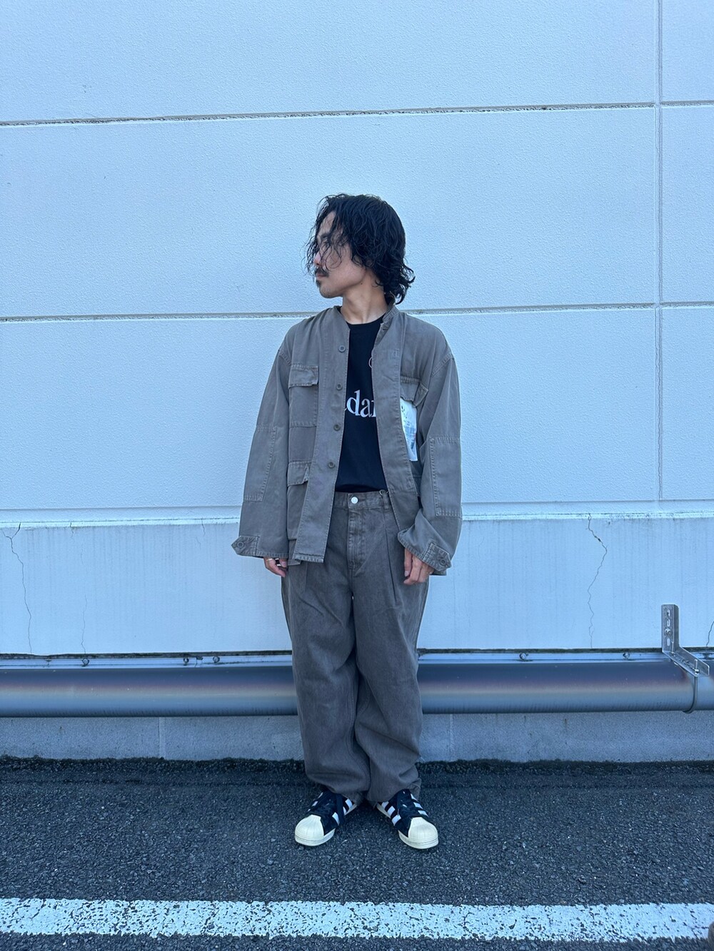 ブラウン系のブルゾン、ブラウン系のデニムパンツ、ブラック系のTシャツ/カットソーを着用したメンズの夏コーディネートの2枚目の写真