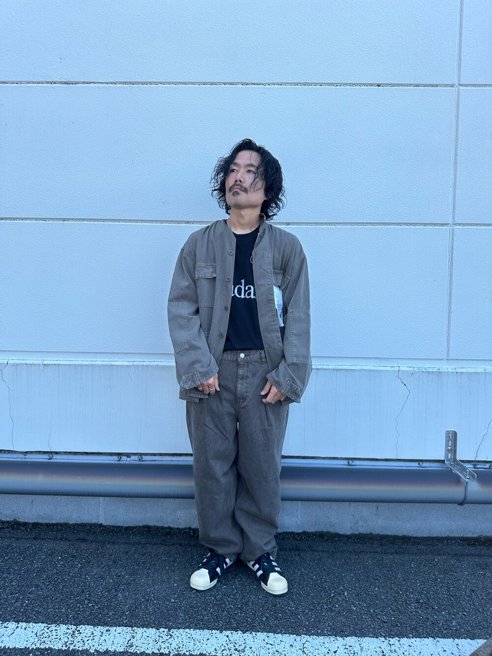 ブラウン系のブルゾン、ブラウン系のデニムパンツ、ブラック系のTシャツ/カットソーを着用したメンズの夏コーディネートの3枚目の写真