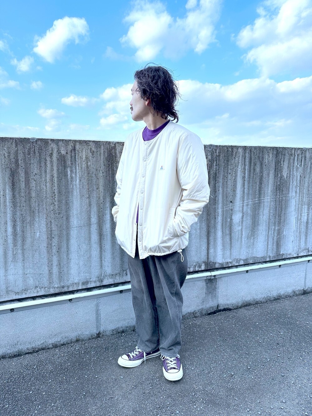 ホワイト系のノーカラージャケットを着用したメンズの冬コーディネートの2枚目の写真