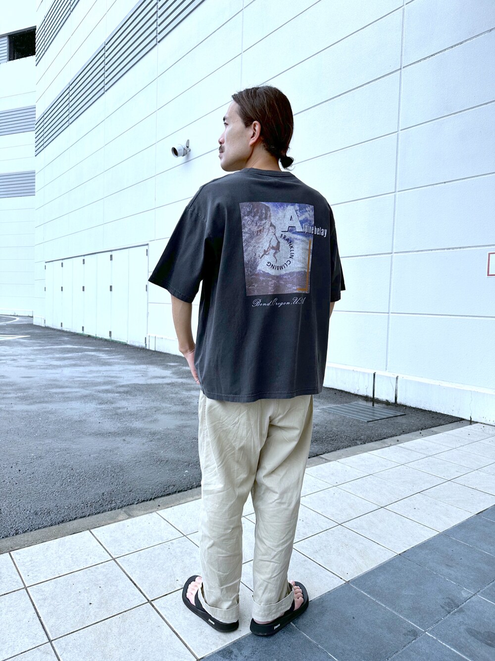 ベージュ系のチノパンツ、ブラック系のTシャツ/カットソーを着用したメンズの夏コーディネートの2枚目の写真