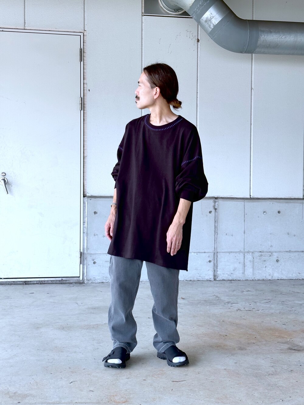 ブラック系のTシャツ/カットソー、ブラック系のデニムパンツを着用したメンズの秋コーディネートの2枚目の写真