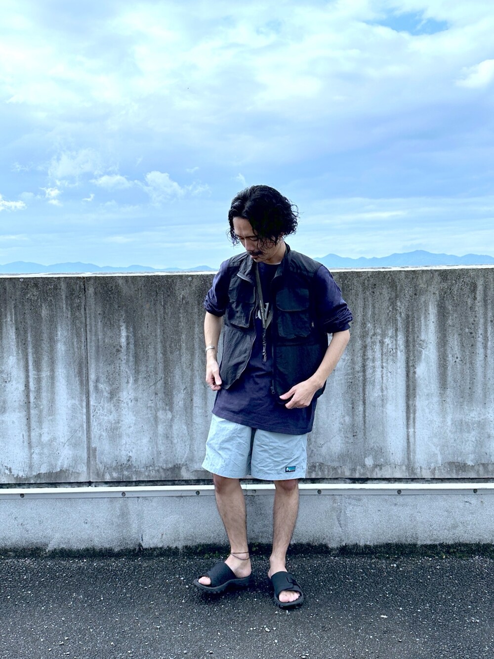 ブラック系のベスト、ブルー系のTシャツ/カットソー、ブルー系のその他パンツを着用したメンズの春コーディネートの2枚目の写真