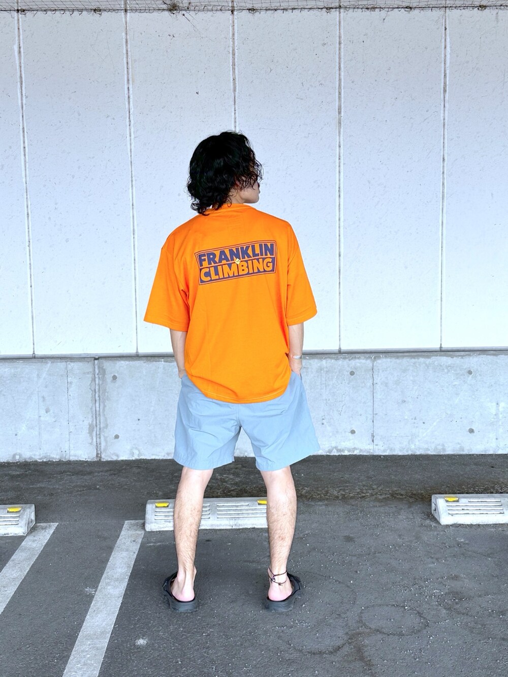 オレンジ系のTシャツ/カットソー、ブルー系のその他パンツを着用したメンズの春コーディネートの2枚目の写真
