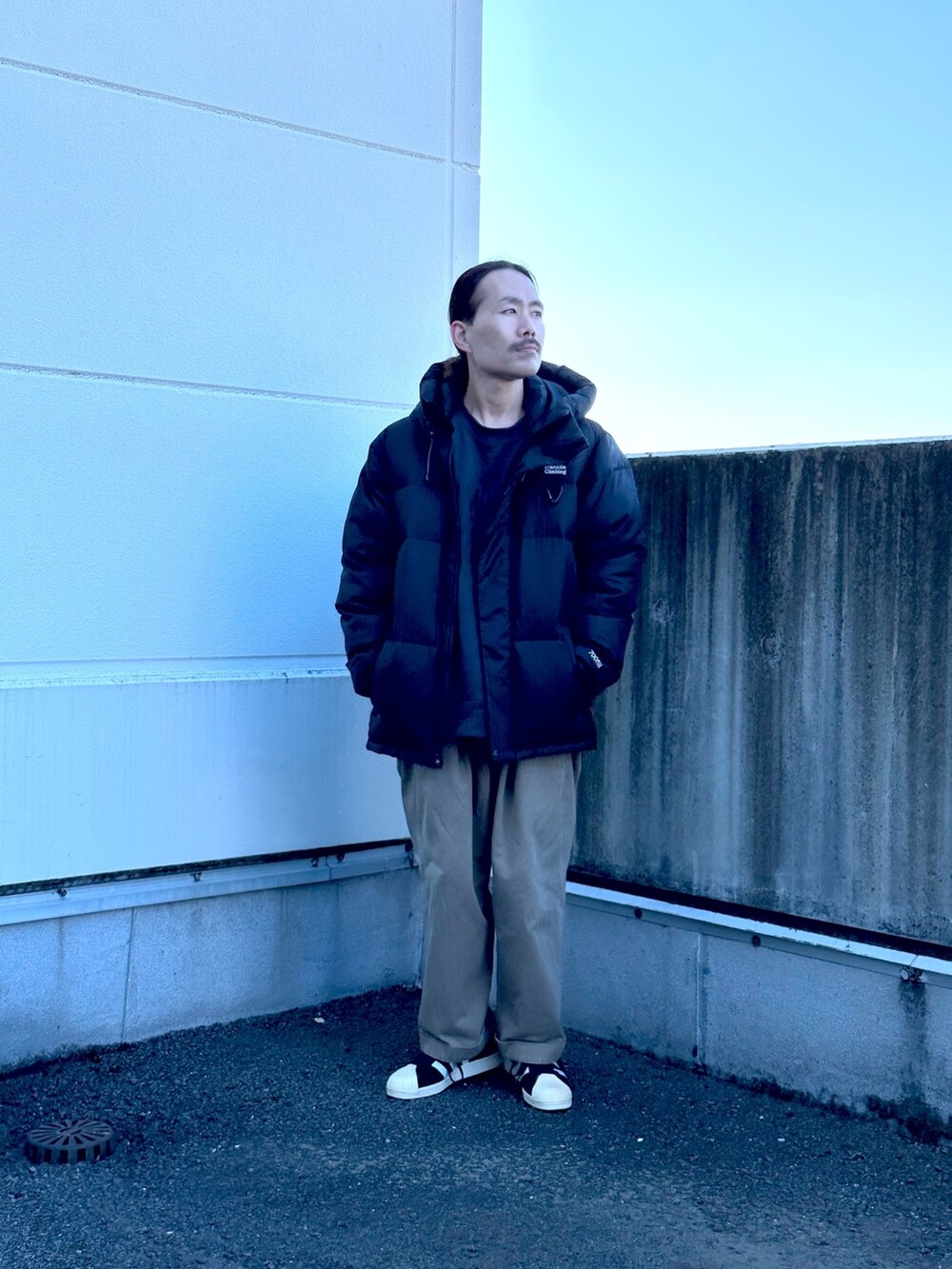 ブラック系のダウンジャケット/コートを着用したメンズの秋コーディネートの2枚目の写真