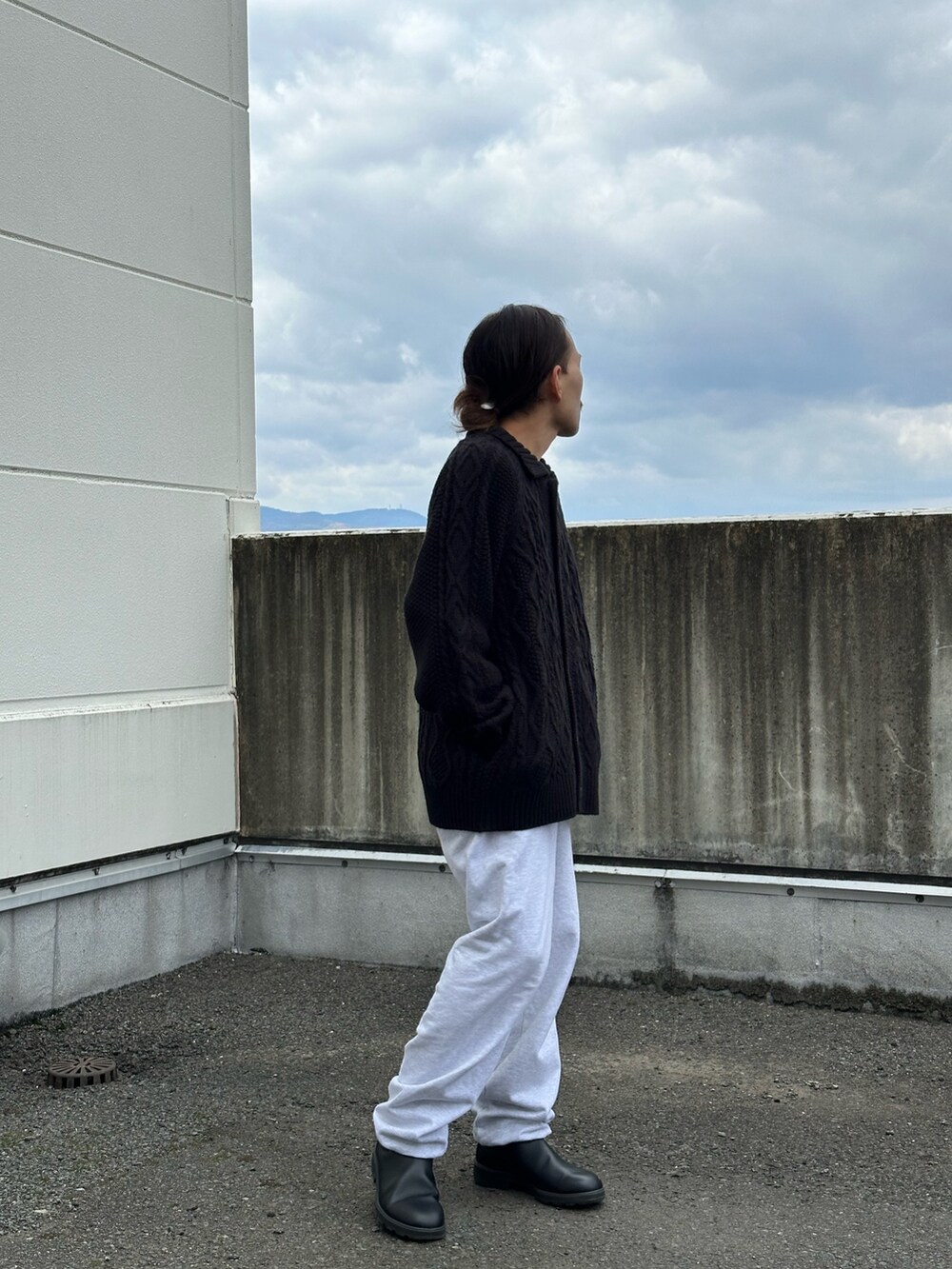 ブラック系のカーディガン/ボレロ、グレー系のスウェットパンツ、ブラック系のブーツを着用したメンズの冬コーディネートの2枚目の写真