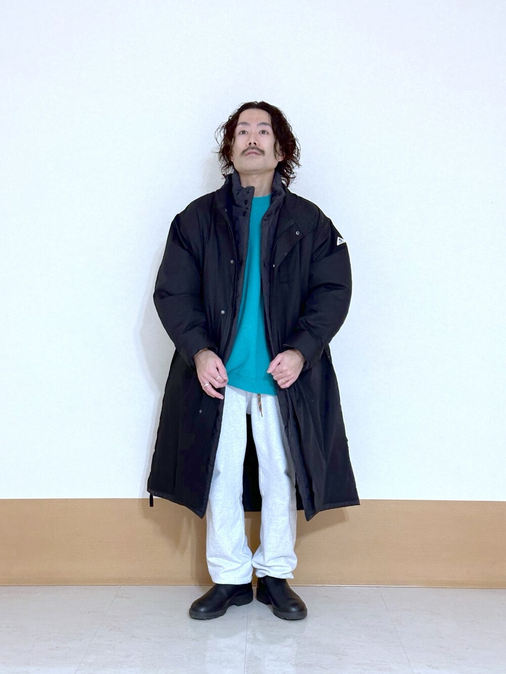 ブラック系のモッズコート、グレー系のスウェットパンツ、ブラック系のブーツを着用したメンズの冬コーディネートの2枚目の写真