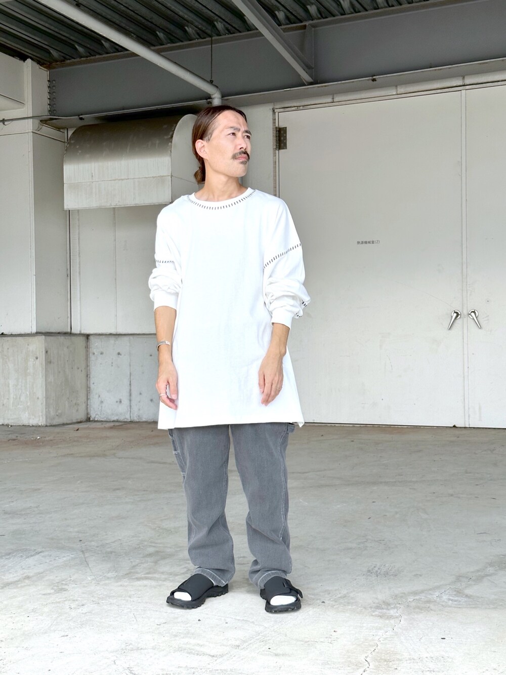 ホワイト系のTシャツ/カットソー、ブラック系のデニムパンツを着用したメンズの秋コーディネートの2枚目の写真