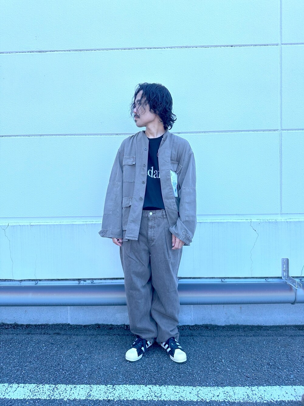 ブラウン系のブルゾン、ブラウン系のデニムパンツ、ブラック系のTシャツ/カットソーを着用したメンズの夏コーディネートの2枚目の写真