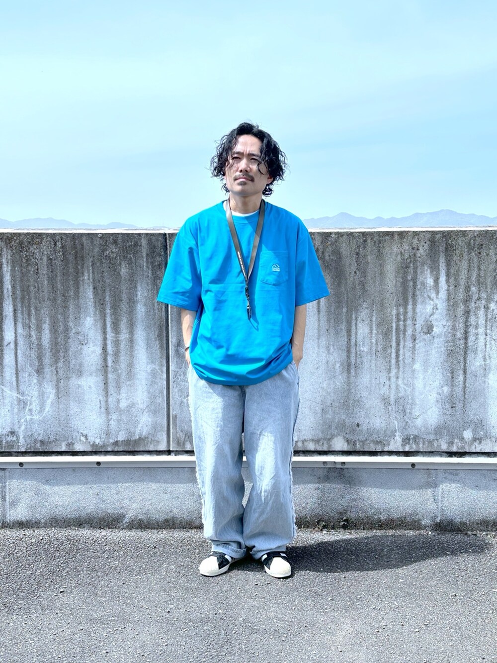 ブルー系のTシャツ/カットソー、ブルー系のデニムパンツを着用したメンズの春コーディネートの2枚目の写真