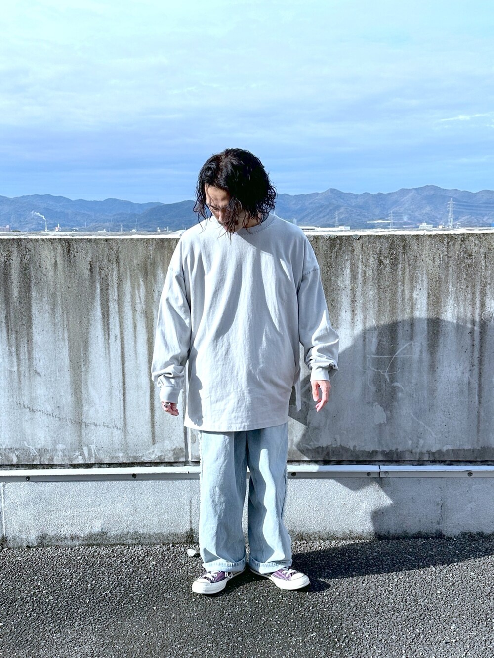 グレー系のTシャツ/カットソー、ブルー系のデニムパンツを着用したメンズの冬コーディネートの2枚目の写真