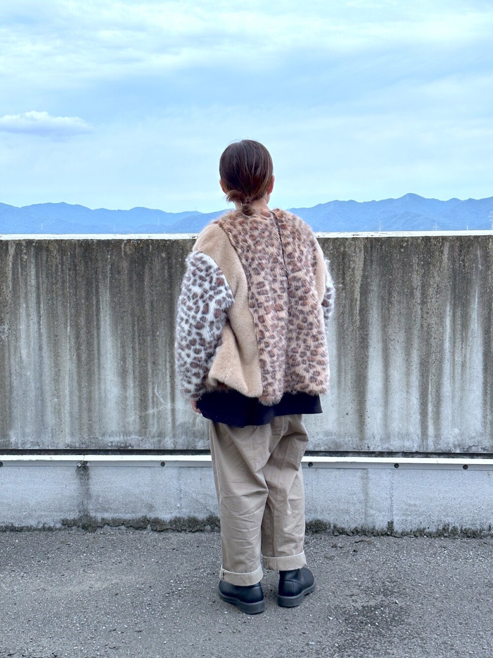 ベージュ系のノーカラーコート、グリーン系のチノパンツ、ブラック系のブーツを着用したメンズの秋コーディネートの2枚目の写真