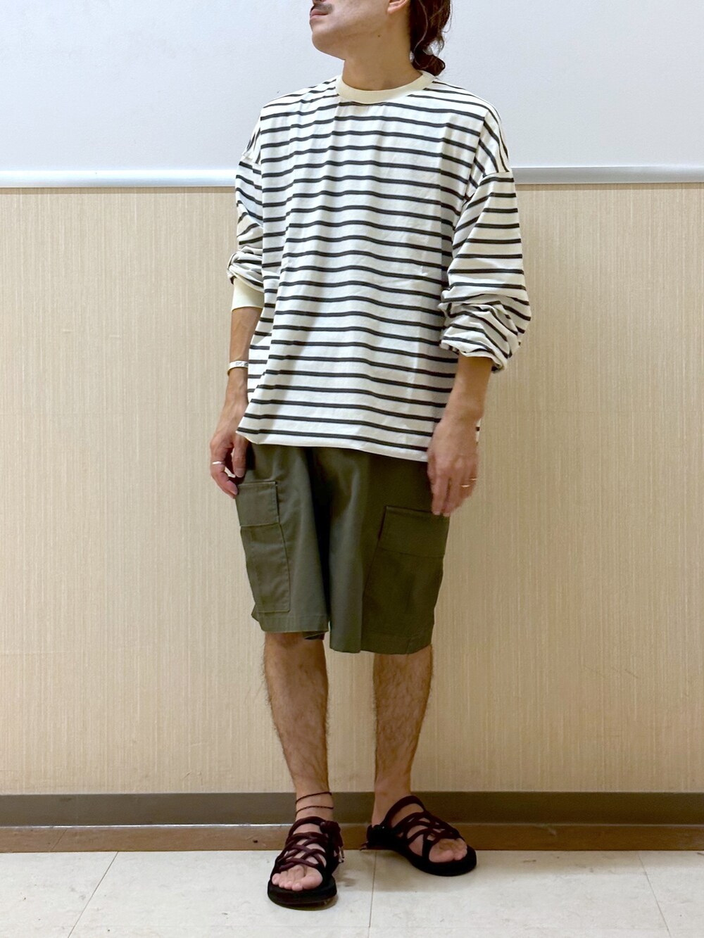 ホワイト系のTシャツ/カットソー、グリーン系のカーゴパンツ、ブラック系のサンダルを着用したメンズの夏コーディネートの2枚目の写真