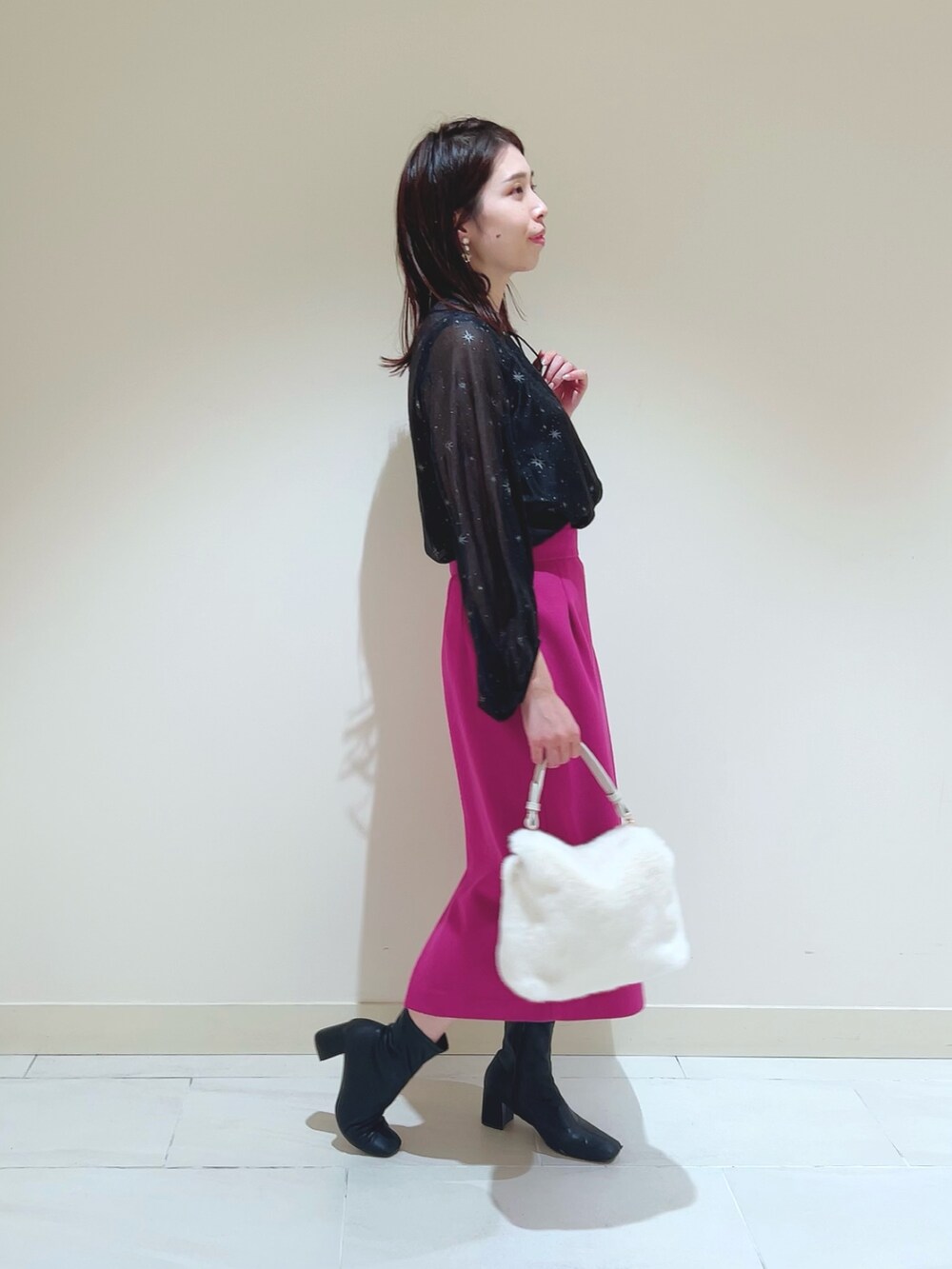 ピンク系のスカート、ブラック系のシャツ/ブラウス、ベージュ系のトレンチコートを着用したレディースの秋コーディネートの7枚目の写真