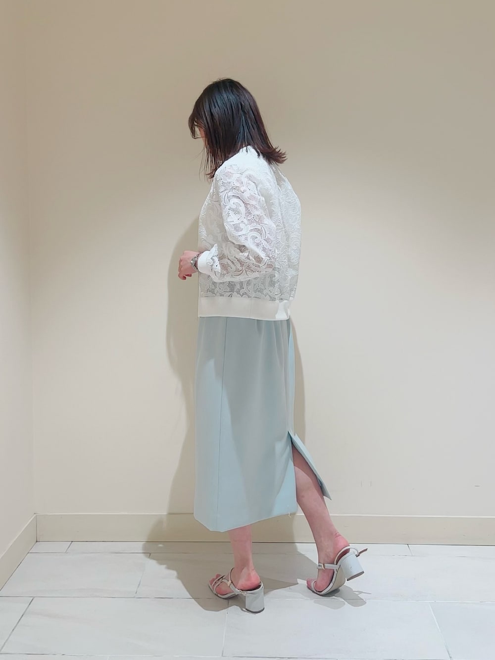 ホワイト系のニット/セーター、ホワイト系のその他トップス、グリーン系のスカートを着用したレディースの春コーディネートの3枚目の写真