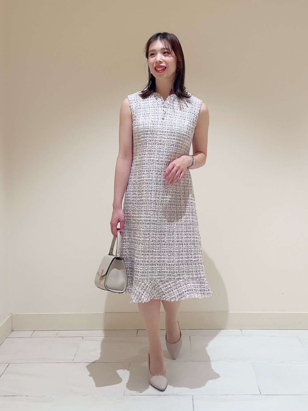 ベージュ系のトートバッグ、ピンク系のノーカラージャケット、ピンク系のワンピースを着用したレディースの春コーディネートの4枚目の写真