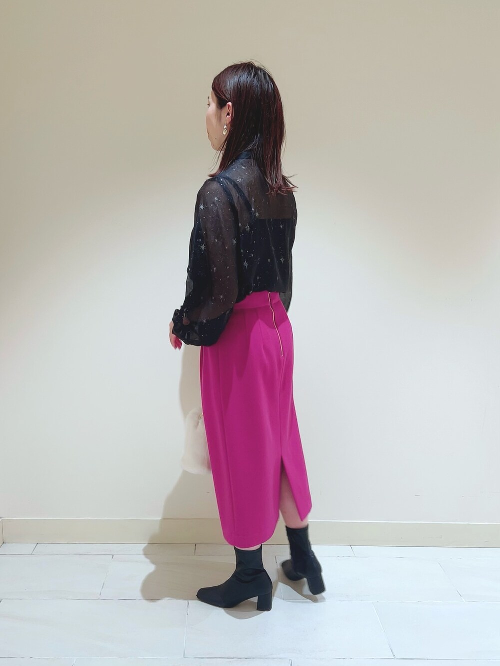 ピンク系のスカート、ブラック系のシャツ/ブラウス、ベージュ系のトレンチコートを着用したレディースの秋コーディネートの6枚目の写真