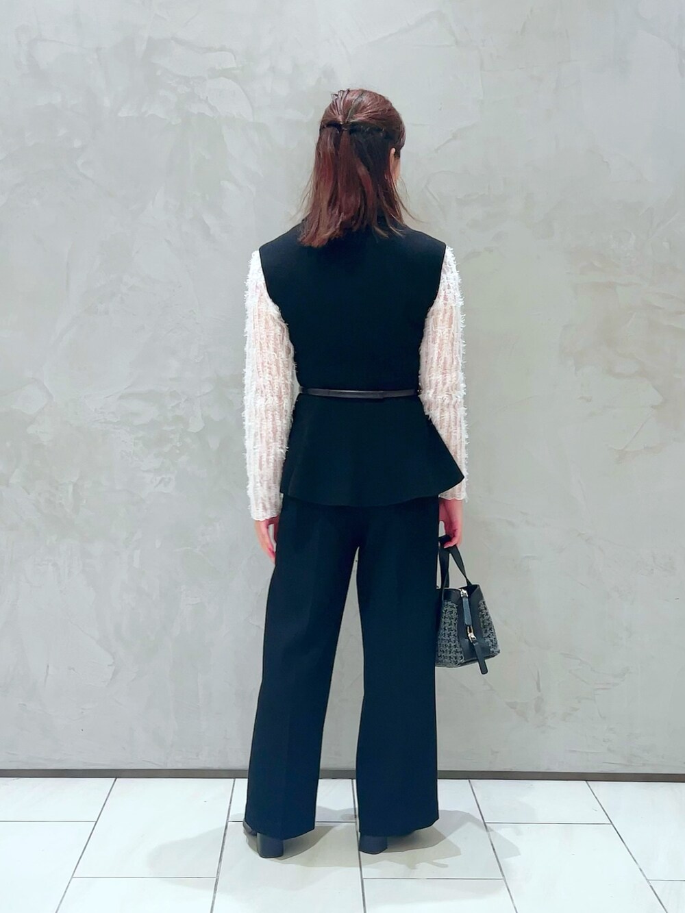 ホワイト系のTシャツ/カットソー、ブラック系のベスト、ブラック系のその他パンツを着用したレディースの秋コーディネートの3枚目の写真