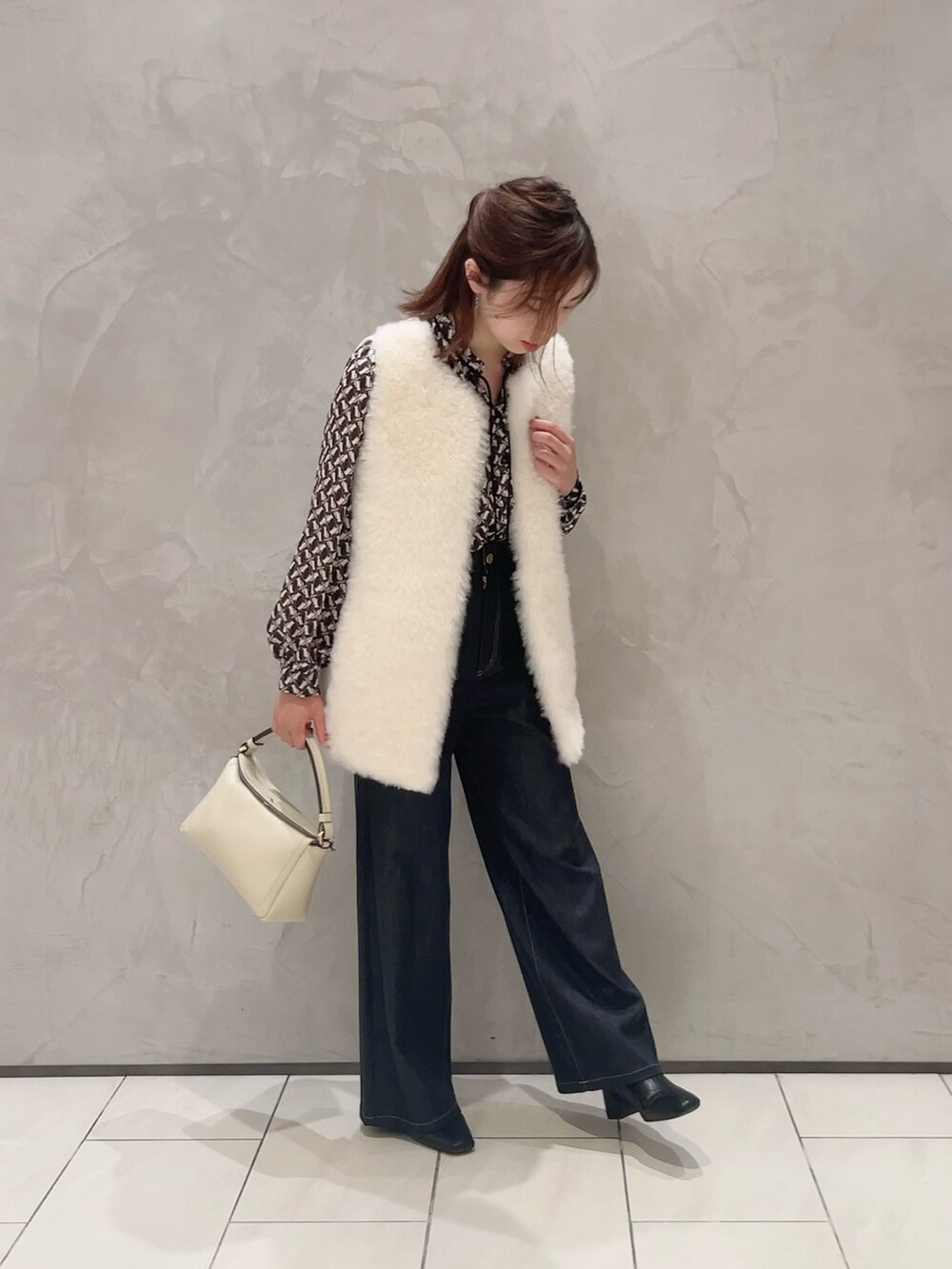 ホワイト系のその他アウター、ブルー系のシャツ/ブラウス、ブルー系のデニムパンツを着用したレディースの秋コーディネートの2枚目の写真