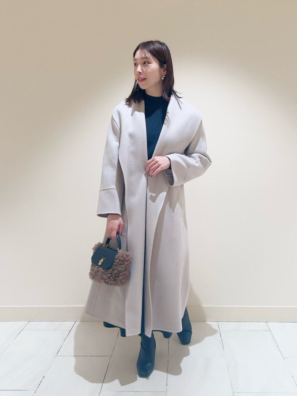 ベージュ系のワンピース、ベージュ系のトレンチコートを着用したレディースの冬コーディネートの2枚目の写真