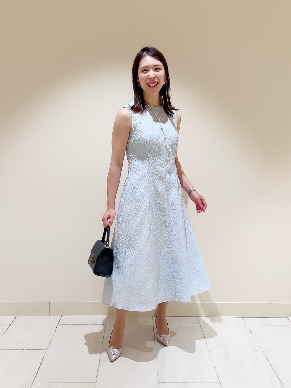 ブルー系のワンピース、ブルー系のテーラードジャケット、ブルー系のトートバッグを着用したレディースの冬コーディネートの6枚目の写真