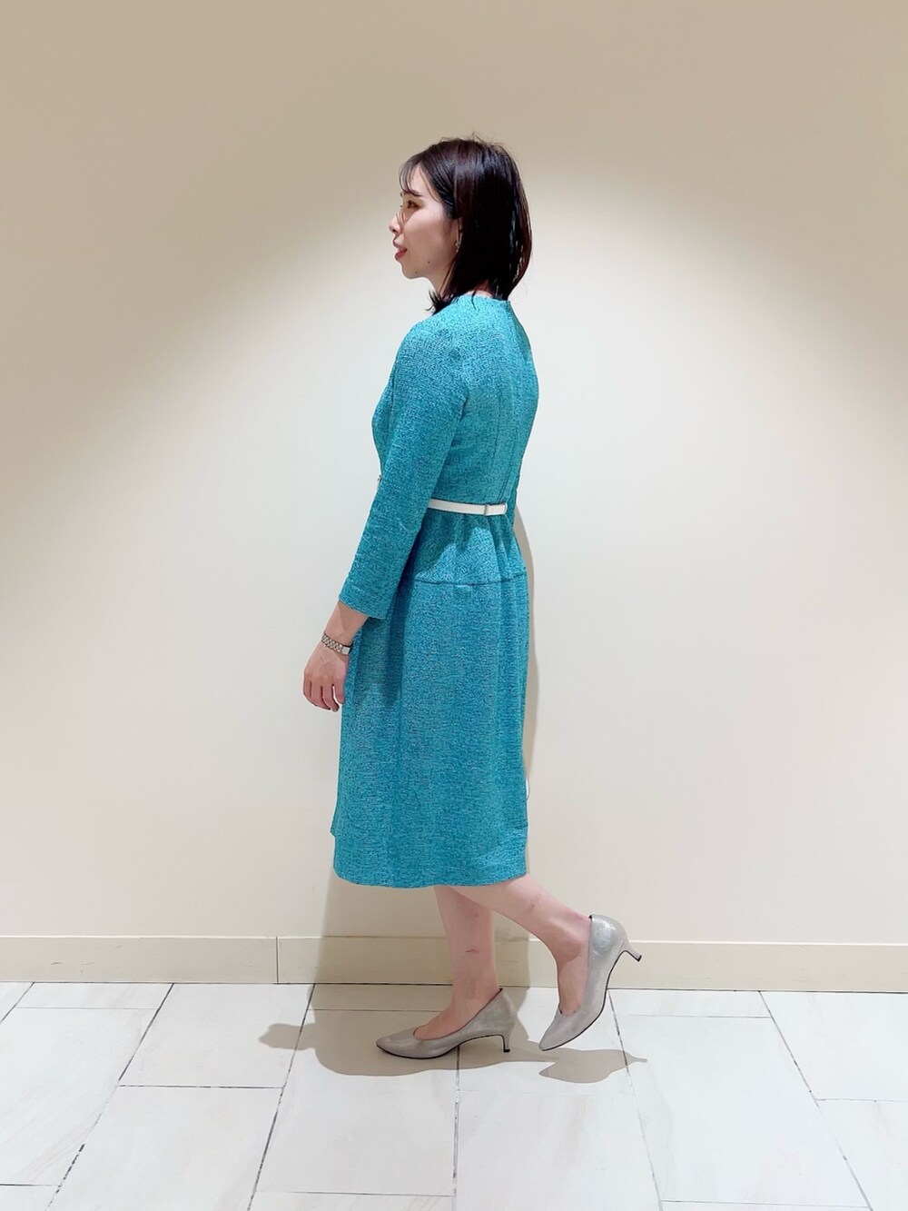 グリーン系のワンピース、ホワイト系のハンドバッグ、ホワイト系のベルトを着用したレディースの春コーディネートの2枚目の写真