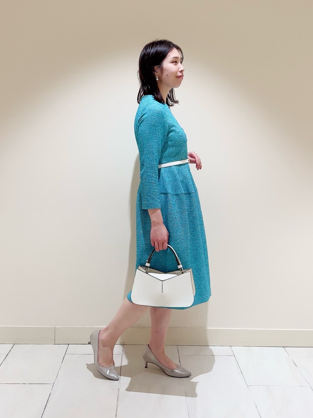 グリーン系のワンピース、ホワイト系のハンドバッグ、ホワイト系のベルトを着用したレディースの春コーディネートの3枚目の写真