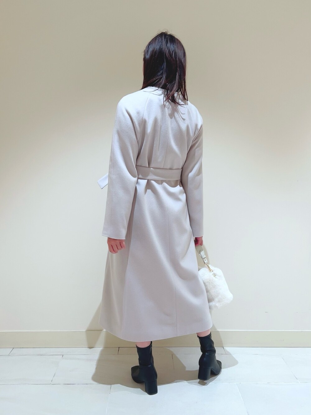 ピンク系のスカート、ブラック系のシャツ/ブラウス、ベージュ系のトレンチコートを着用したレディースの秋コーディネートの4枚目の写真