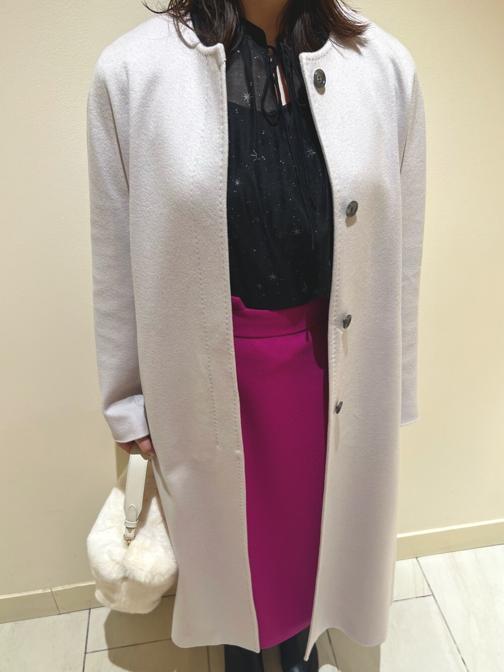 ピンク系のスカート、ブラック系のシャツ/ブラウス、ベージュ系のトレンチコートを着用したレディースの秋コーディネートの9枚目の写真