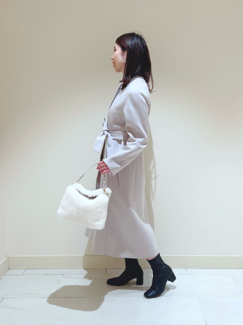 ピンク系のスカート、ブラック系のシャツ/ブラウス、ベージュ系のトレンチコートを着用したレディースの秋コーディネートの3枚目の写真