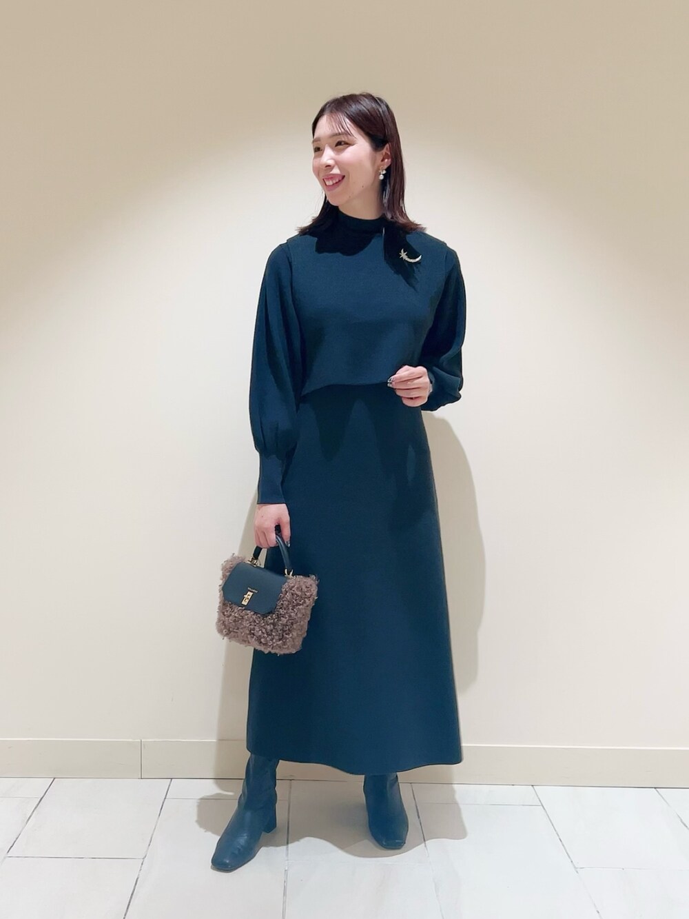 ベージュ系のワンピース、ベージュ系のトレンチコートを着用したレディースの冬コーディネートの6枚目の写真