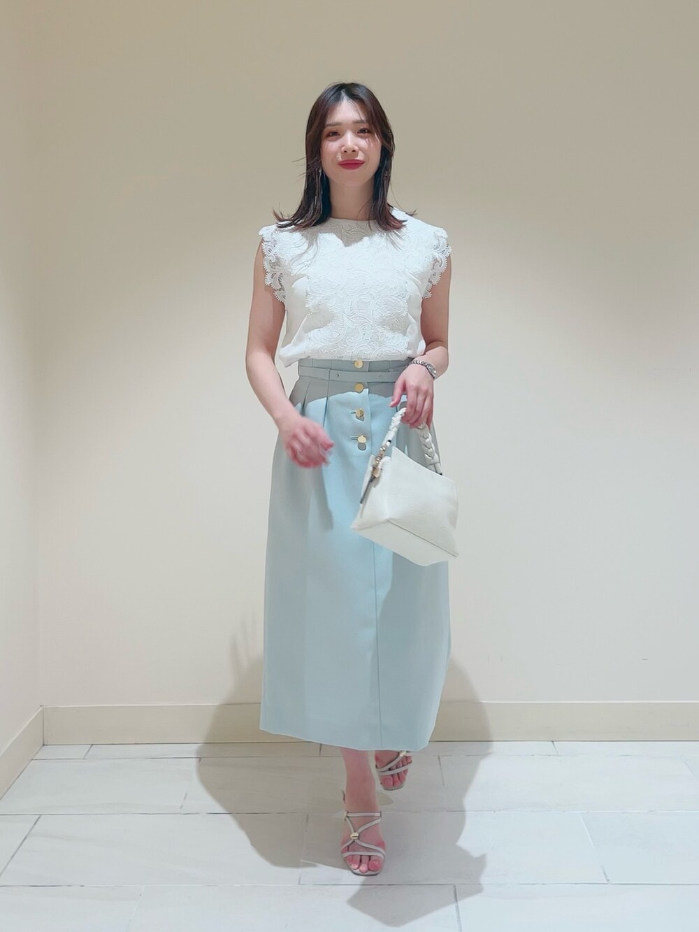 ホワイト系のニット/セーター、ホワイト系のその他トップス、グリーン系のスカートを着用したレディースの春コーディネートの4枚目の写真