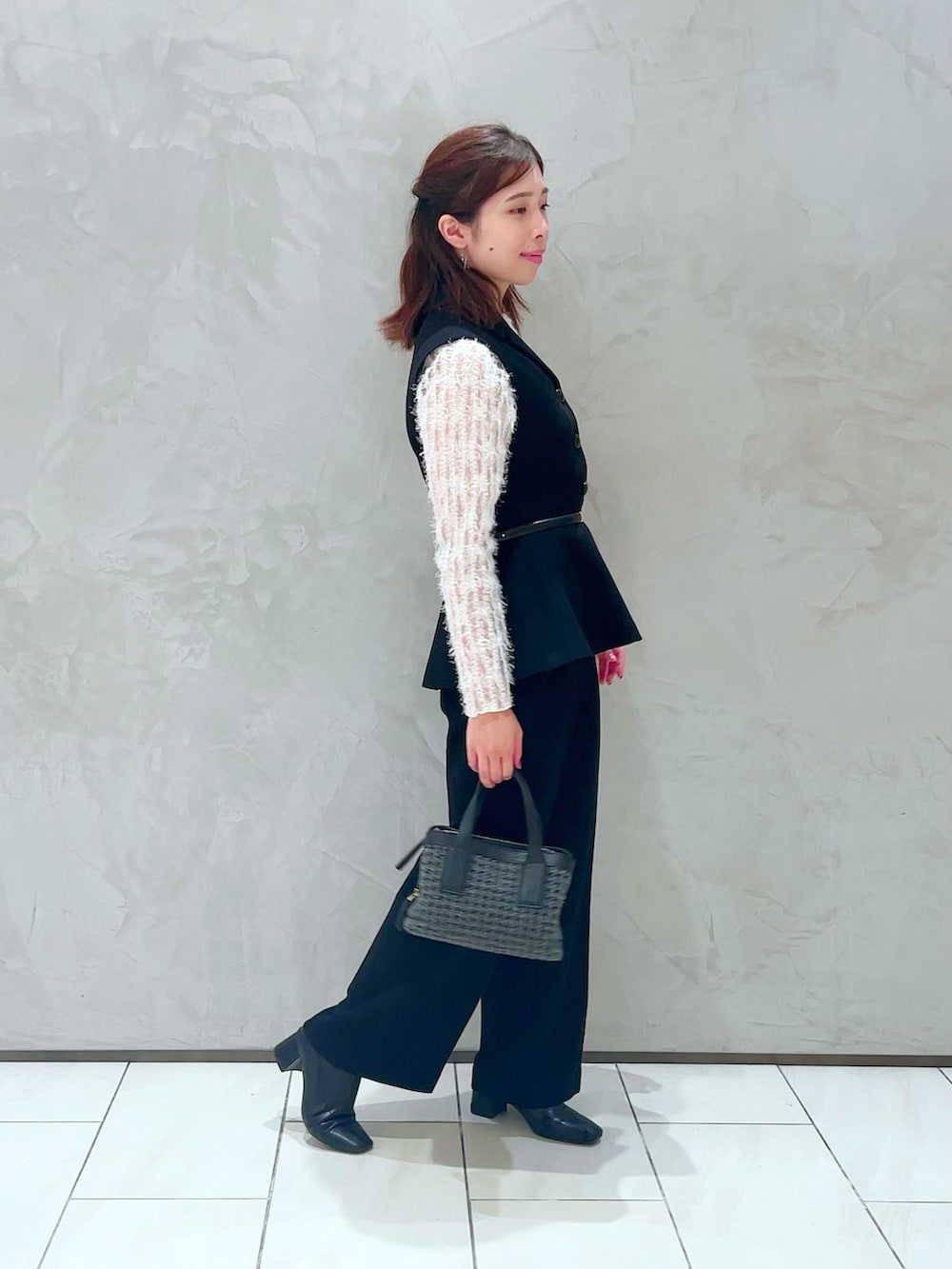 ホワイト系のTシャツ/カットソー、ブラック系のベスト、ブラック系のその他パンツを着用したレディースの秋コーディネートの4枚目の写真