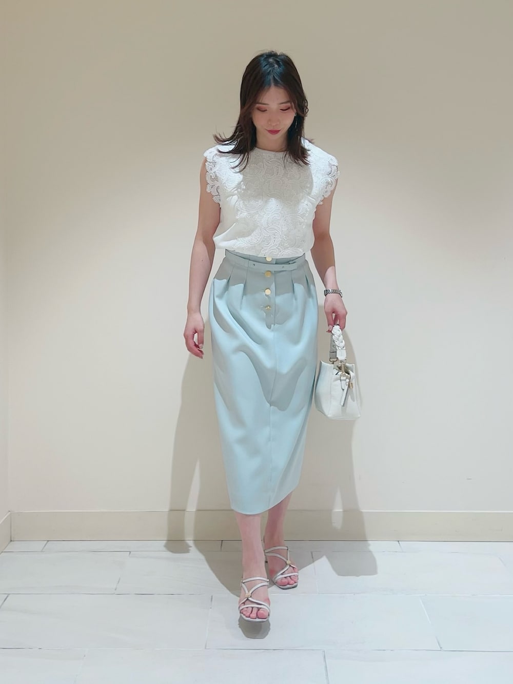 ホワイト系のニット/セーター、ホワイト系のその他トップス、グリーン系のスカートを着用したレディースの春コーディネートの7枚目の写真