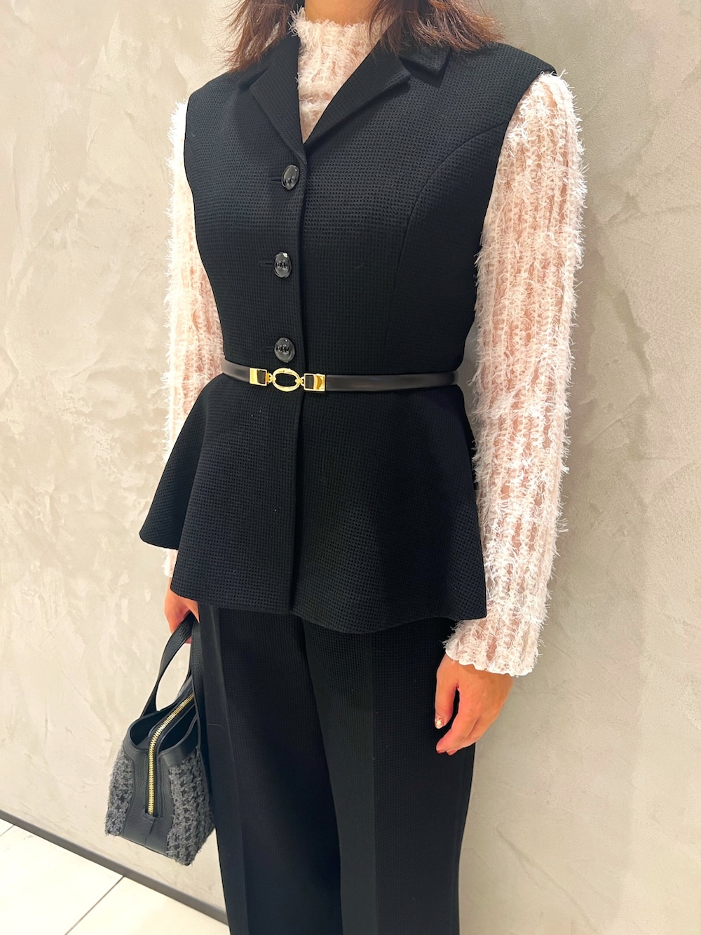 ホワイト系のTシャツ/カットソー、ブラック系のベスト、ブラック系のその他パンツを着用したレディースの秋コーディネートの6枚目の写真