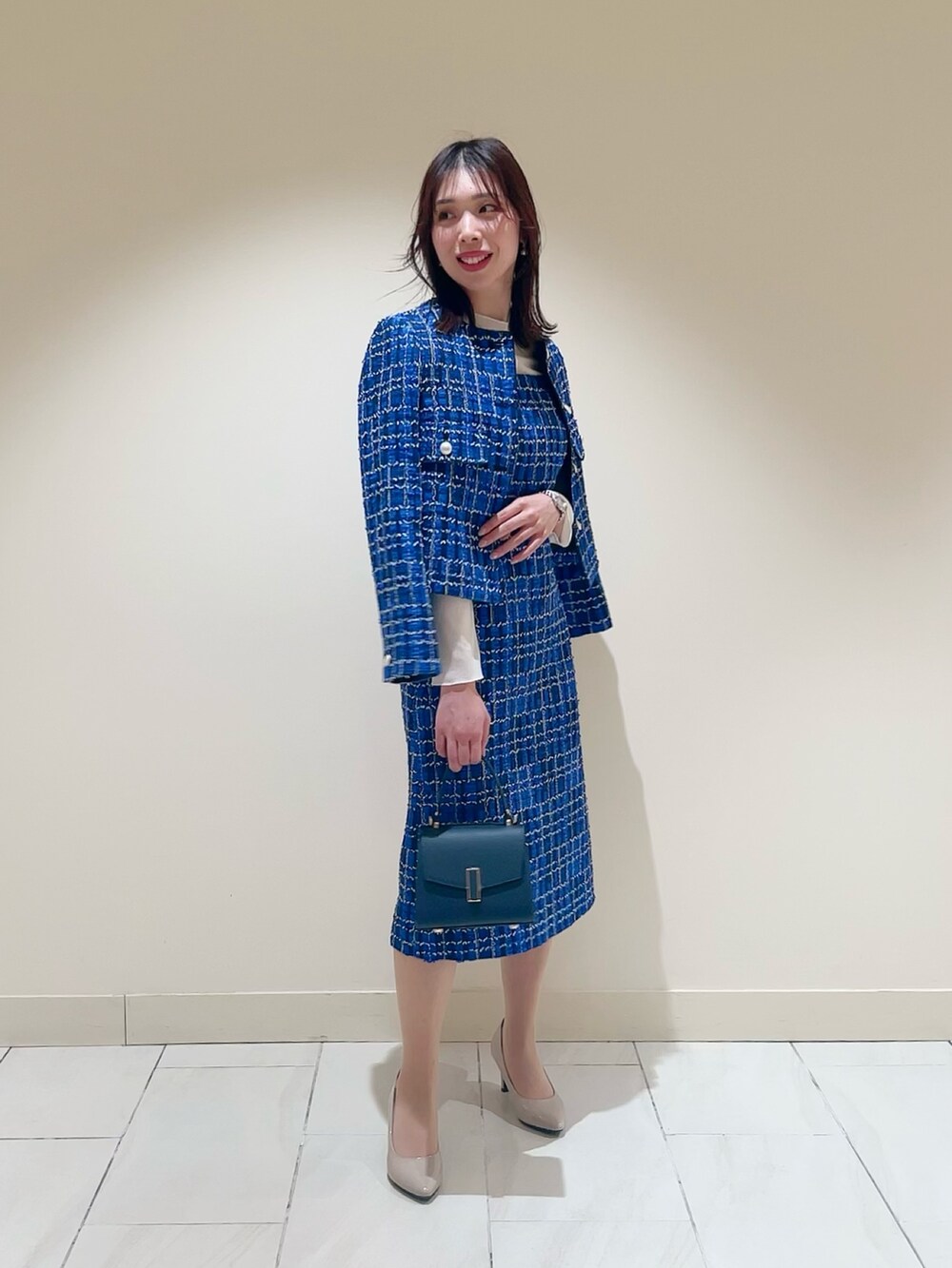ホワイト系のTシャツ/カットソー、ブルー系のトートバッグ、ブルー系のノーカラージャケットを着用したレディースの春コーディネートの2枚目の写真