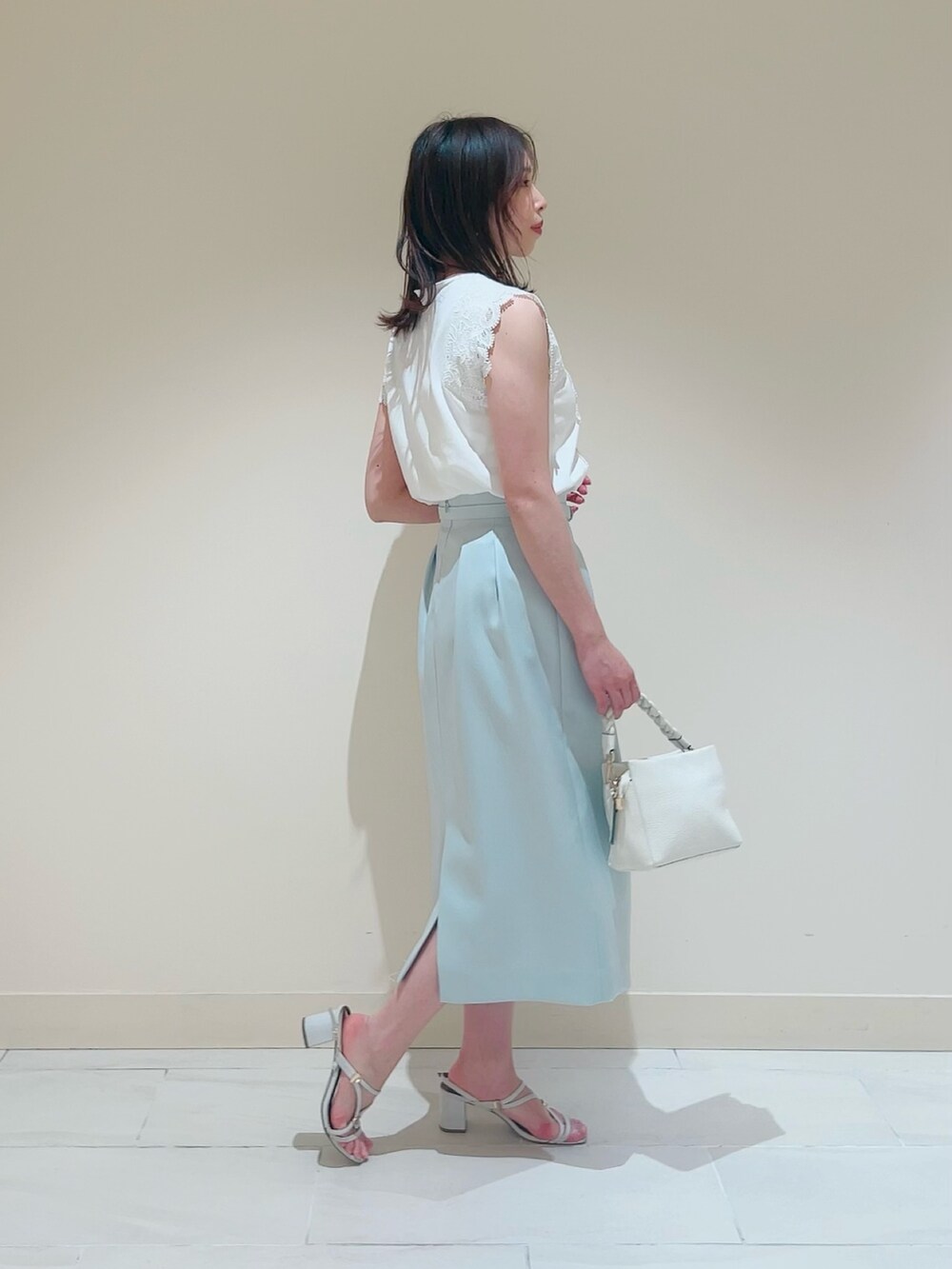 ホワイト系のニット/セーター、ホワイト系のその他トップス、グリーン系のスカートを着用したレディースの春コーディネートの5枚目の写真