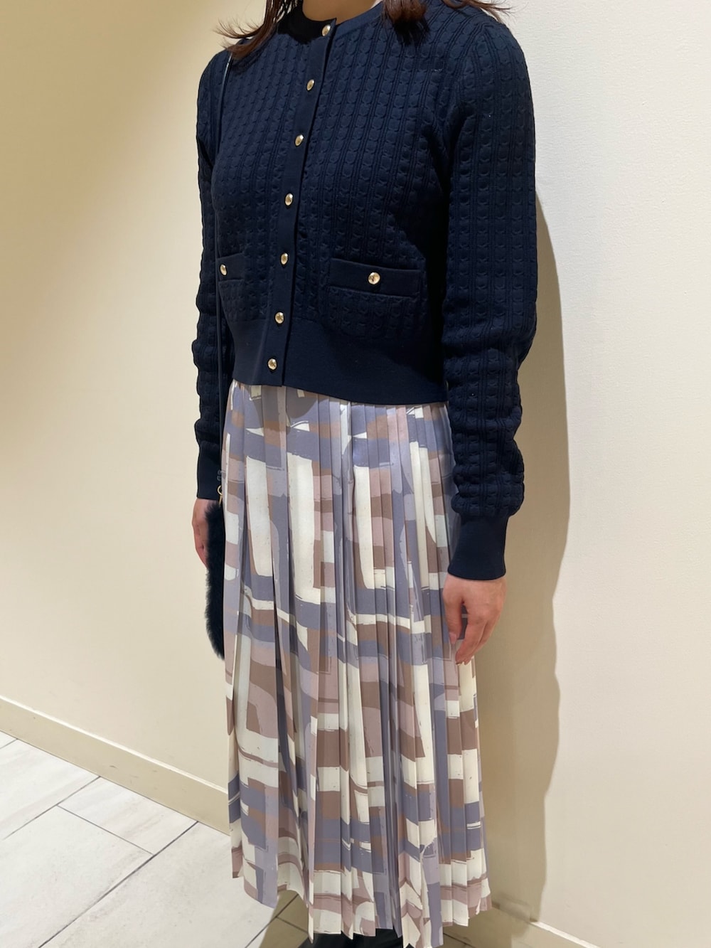 ホワイト系のダウンジャケット/コート、ブルー系のカーディガン/ボレロ、ベージュ系のスカートを着用したレディースの冬コーディネートの8枚目の写真