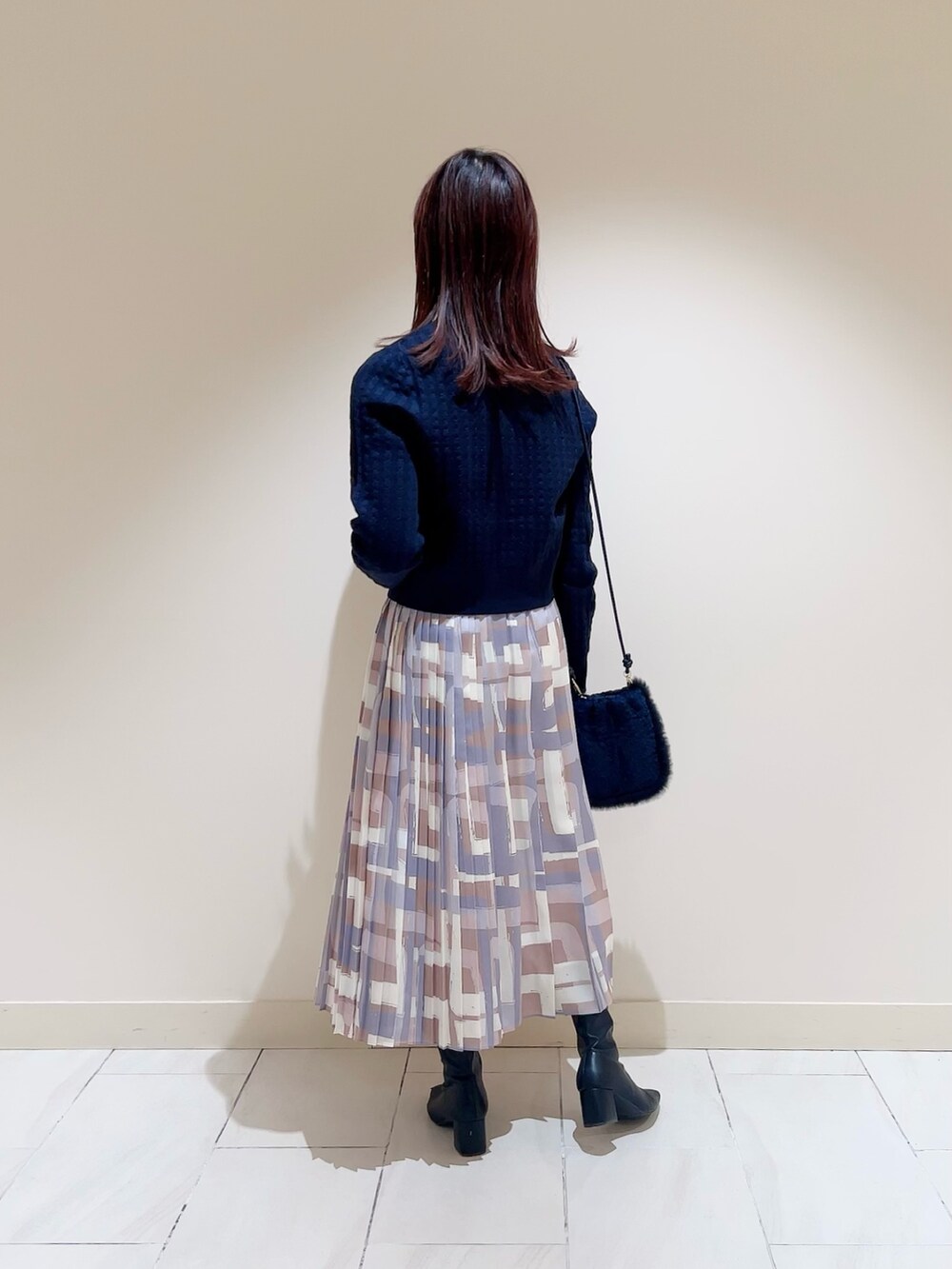 ホワイト系のダウンジャケット/コート、ブルー系のカーディガン/ボレロ、ベージュ系のスカートを着用したレディースの冬コーディネートの7枚目の写真