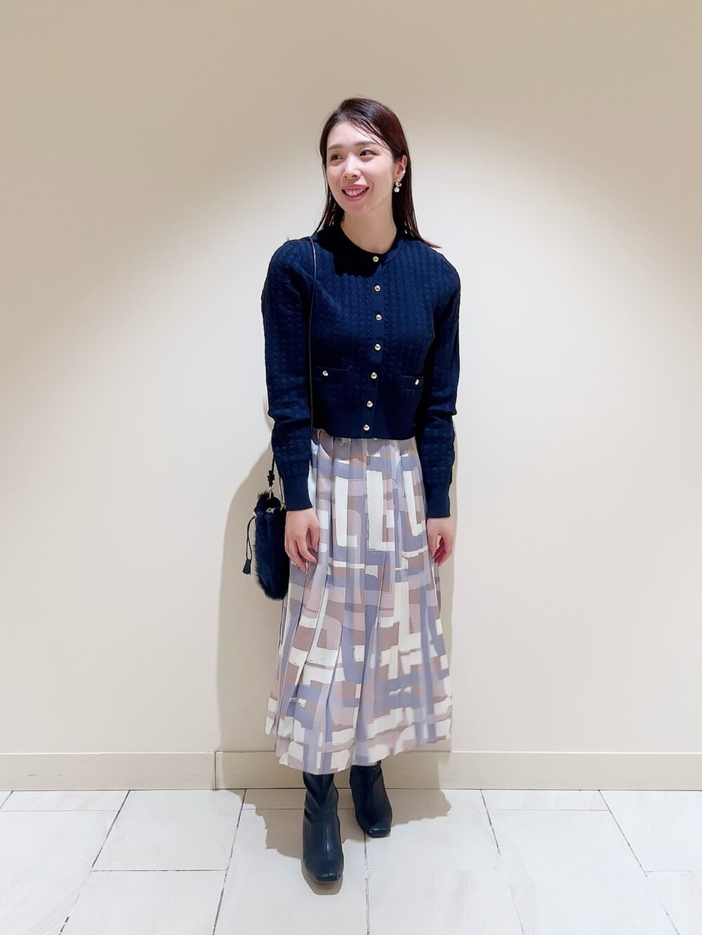 ホワイト系のダウンジャケット/コート、ブルー系のカーディガン/ボレロ、ベージュ系のスカートを着用したレディースの冬コーディネートの5枚目の写真