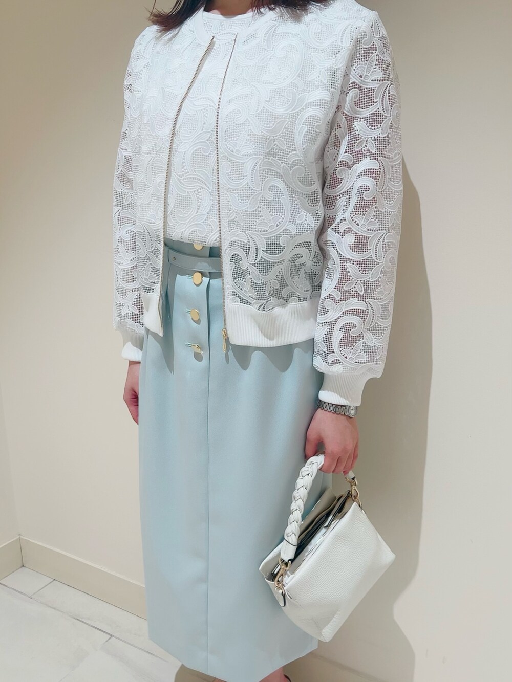 ホワイト系のニット/セーター、ホワイト系のその他トップス、グリーン系のスカートを着用したレディースの春コーディネートの9枚目の写真