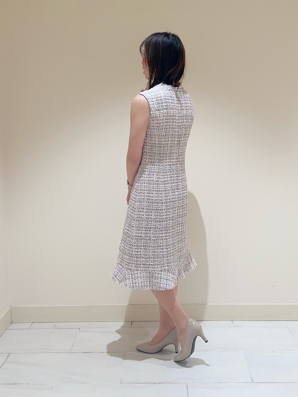 ベージュ系のトートバッグ、ピンク系のノーカラージャケット、ピンク系のワンピースを着用したレディースの春コーディネートの5枚目の写真