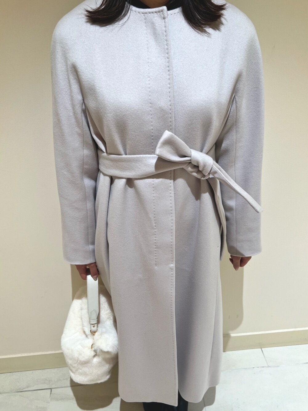 ピンク系のスカート、ブラック系のシャツ/ブラウス、ベージュ系のトレンチコートを着用したレディースの秋コーディネートの10枚目の写真