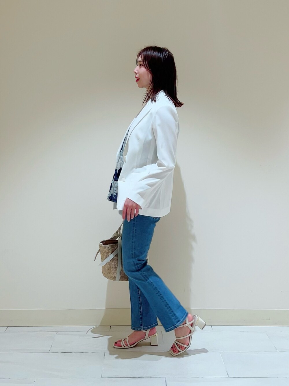 ブルー系のデニムパンツを着用したレディースの春コーディネートの2枚目の写真