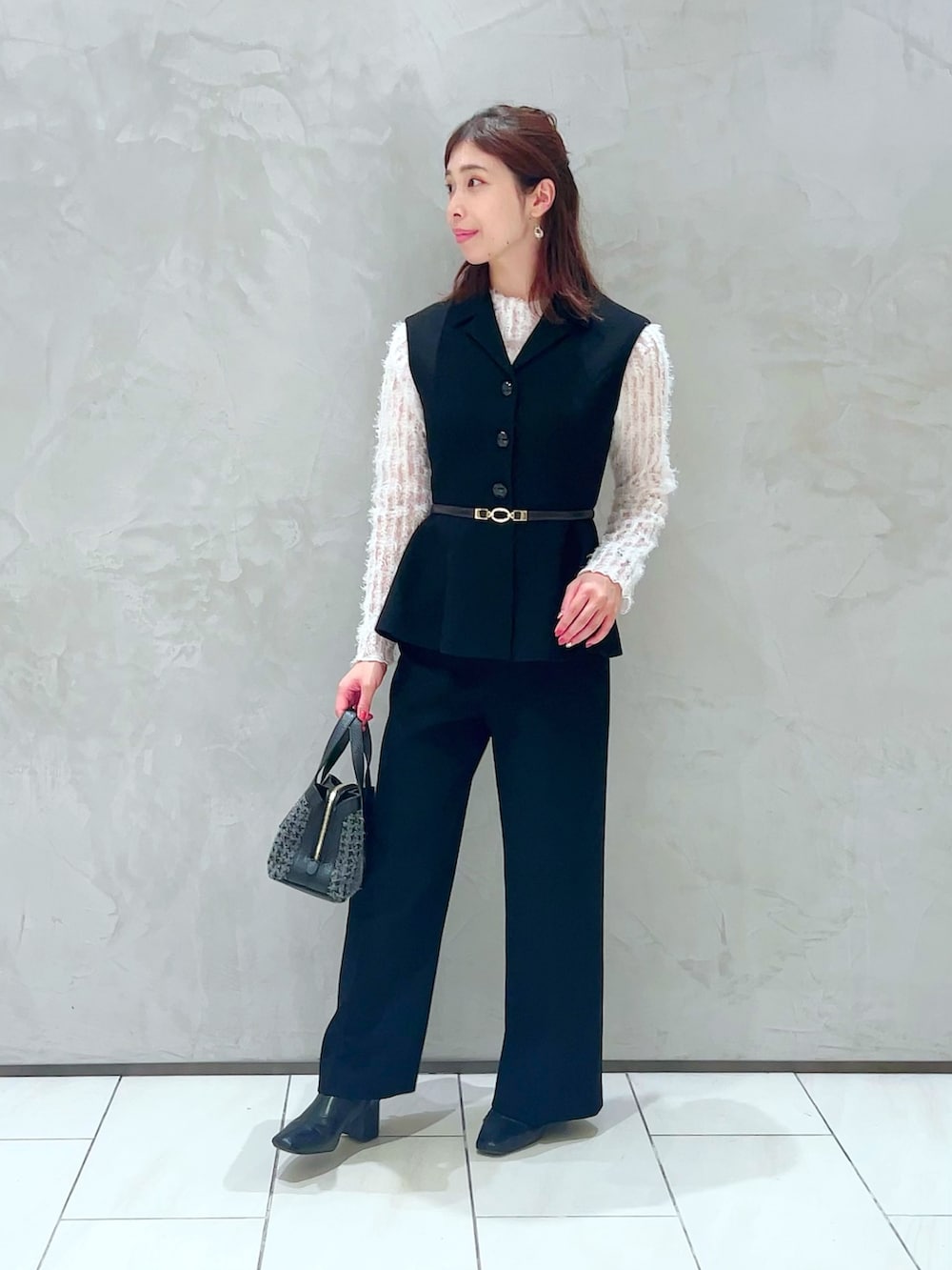 ホワイト系のTシャツ/カットソー、ブラック系のベスト、ブラック系のその他パンツを着用したレディースの秋コーディネートの2枚目の写真