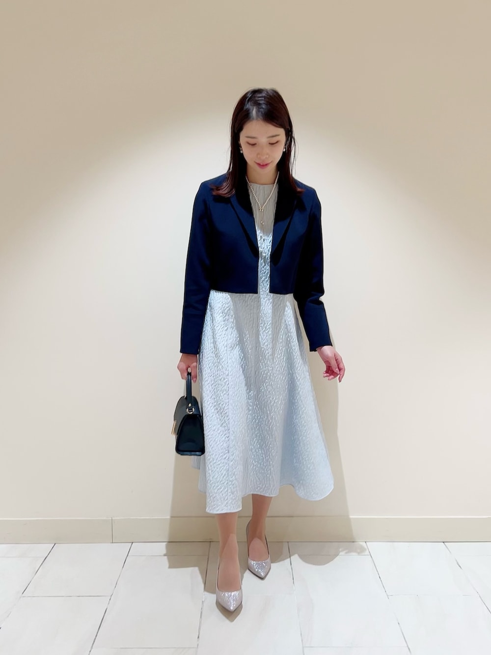 ブルー系のワンピース、ブルー系のテーラードジャケット、ブルー系のトートバッグを着用したレディースの冬コーディネートの5枚目の写真