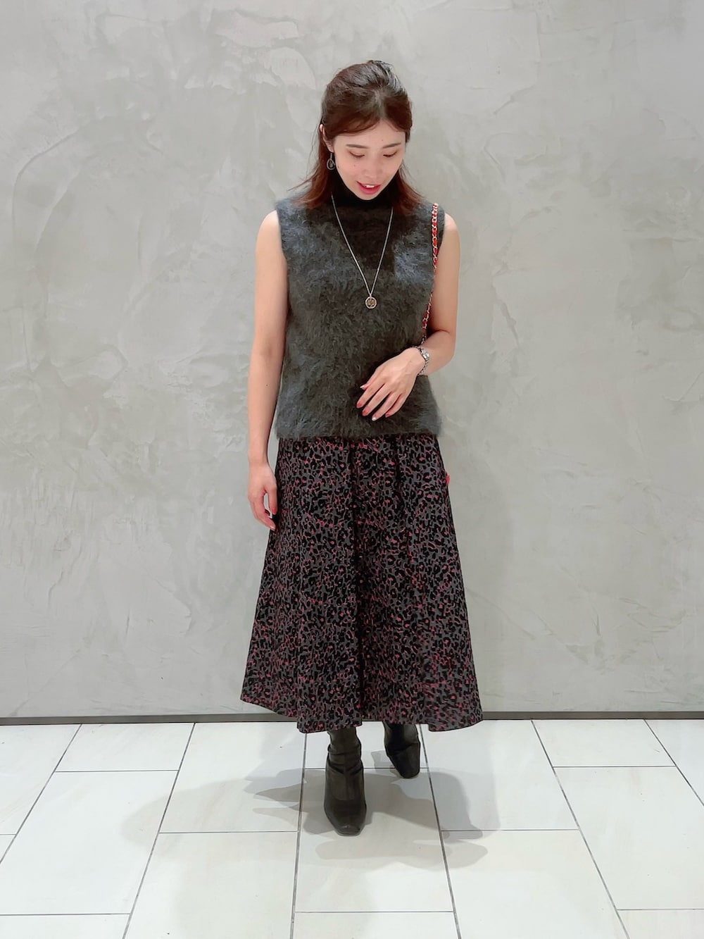 ピンク系のスカート、グレー系のその他トップス、ゴールド系のネックレスを着用したレディースの秋コーディネートの5枚目の写真