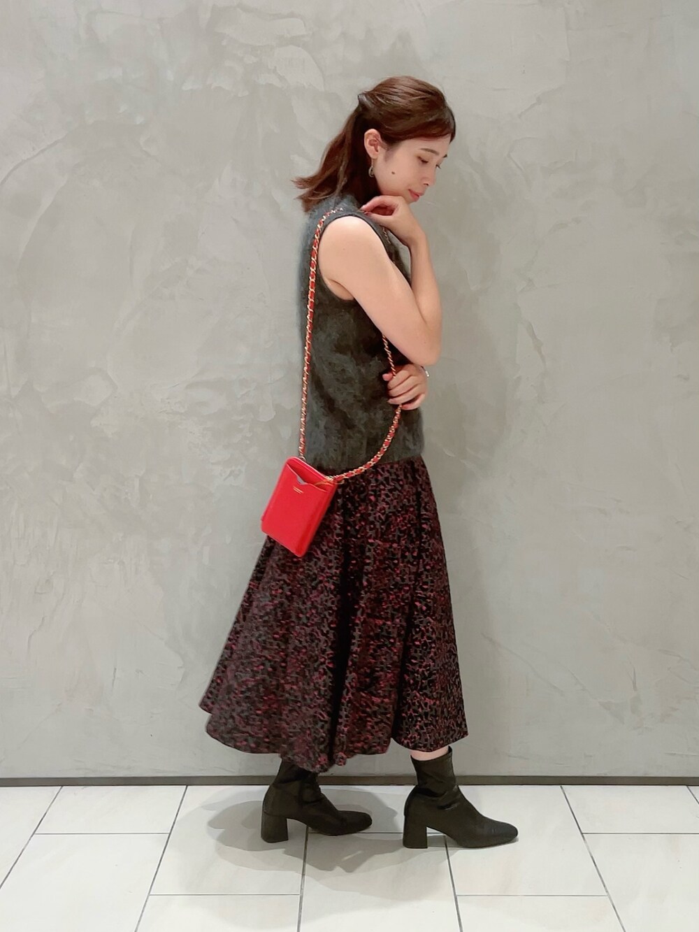 ピンク系のスカート、グレー系のその他トップス、ゴールド系のネックレスを着用したレディースの秋コーディネートの3枚目の写真